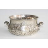 A Victorian silver twin handled porringer, having Rococo style floral repousse decoration and