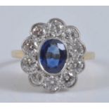 A yellow and white metal, sapphire and diamond oval cluster ring, featuring a centre oval sapphire