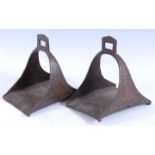 A pair of 19th century Indo-Persian wrought iron stirrups, having rectangular treads the