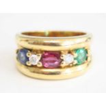 A yellow metal, sapphire, ruby, emerald and diamond five stone half hoop ring, the oval sapphire