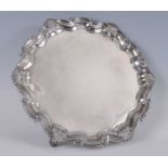 A Victorian silver salver, of shaped circular form, having stepped scrolling and shell cast rim,