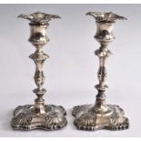 A pair of late Victorian silver candlesticks, of knopped baluster form to a shaped square loaded