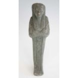 An Egyptian green painted pottery shabti figure, in typical standing pose, with arms crossed and