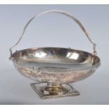 An Edwardian silver swing handle pedestal sweetmeat dish, of circular form with Greek Key and mask