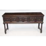 An 18th century and later joined oak dresser base, the two-plank top over three geometrically