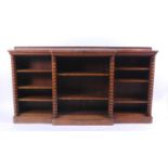 A Victorian figured walnut breakfront open bookcase, the top with rosewood crossbanding, the whole