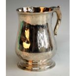 An early George III silver tankard, of squat baluster form to a stepped foot, having acanthus leaf