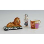 A 19th century hard paste procelain model of a recumbent lion, upon a green scrolled base, h.9cm,