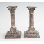 A pair of Edwardian silver neo-classical candlesticks, of Corinthian column form with acanthus