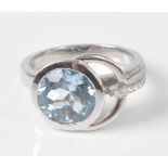 An 18ct white gold, aquamarine and diamond stirrup shaped dress ring, comprising a round faceted