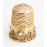 A yellow metal pearl set thimble, the four 2.3mm half pearls in off-square settings with cannetile