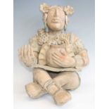 A large Mexican pottery figure, modelled as a female in seated cross legged pose, her left hand