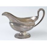 A George III white metal 'duty dodger' sauceboat, of elongated oval form with gadrooned rim and