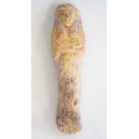 An Egyptian pottery shabti, the mummiform figure modelled with tripartite wig and hands crossed on