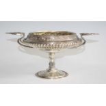 A late Victorian silver pedestal comport bowl, having applied stylised pierced handles, the bowl