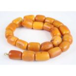 A heavy beaded butterscotch amber single string necklace, comprising 23 rough barrel beads of