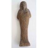 An Egyptian moulded and tooled shabti figure, in typical standing pose, with hieroglyphs to the