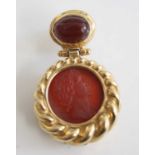 A yellow metal single carnelian drop earring, comprising an 11.85mm round carnelian intaglio