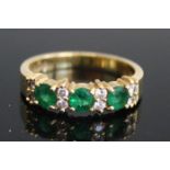An 18ct yellow gold, emerald and diamond half hoop eternity ring, comprising three round faceted