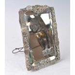 A Victorian silver framed easel dressing table mirror, the silver pierced surround of shaped