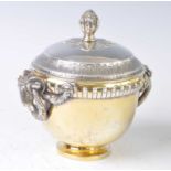 A late Victorian silver and silver-gilt urn and cover, the circular body with rams head and wreath