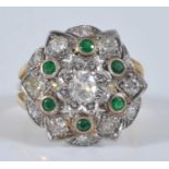 A yellow and white metal, emerald and diamond circular cluster ring, featuring a centre old