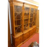 A contemporary yew wood break front bookcase cupboard, the four astragal glazed upper doors with