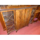 A 1930s mahogany and flame mahogany breakfront bookcase, having twin panelled doors flanked by