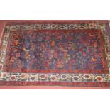 A Persian woollen blue ground rug, the central ground decorated with stylised birds amongst foliage,