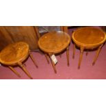 A set of three contemporary mahogany and crossbanded circular low occasional tables, raised on