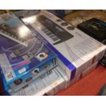 Five various boxed electronic keyboards and a box containing a quantity of headphones