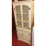 An Old Charm cream painted oak bookcase, with twin lead glazed upper doors, width 63cm