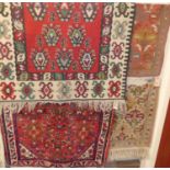 A Turkish woollen red ground rug; together with a Persian woollen red ground Tabriz rug; and two