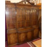 A contemporary mahogany and flame mahogany breakfront library bookcase, having four glazed upper