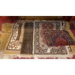 Four various machine woven rugs; together with a Persian cushion (5)