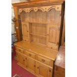 A contemporary joined light oak dresser, having twin shelves, recessed panelled cupboard doors and
