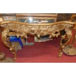 A contemporary French style floral gilt decorated serpentine console table, having a mirrored