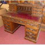 A good circa 1900 heavily carved oak twin pedestal writing desk, having a raised super structure
