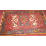A Persian woollen red ground Shiraz rug, 195 x 129cm