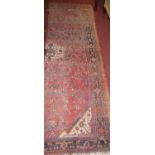 A Persian woollen red ground rug, 275 x 155cm