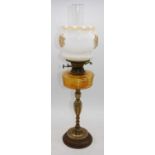 A 19th century brass oil lamp, having milk glass shade and amber glass font, overall h.67cm