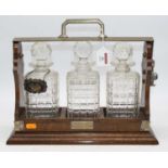 An early 20th century oak three decanter tantalus, w.38cmTantalus not marked Betjeman