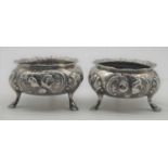 A pair of Victorian silver open salts, each of squat circular form with gadrooned rim, repousse