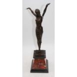 An Art Deco style bronzed figure of a lady with her arms raised, standing upon a polished