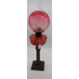 A 19th century brass oil lamp, having acid etched cranberry glass shade and cranberry font, h.