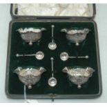 A set of four Edwardian silver open salts, each having a flared rim, floral repousse body and raised