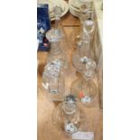 A collection of seven cut glass decanters, several with enamel labels, the largest 34cm