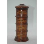 A reproduction fruitwood four-section cylindrical spice tower, each section annotated for Cloves,