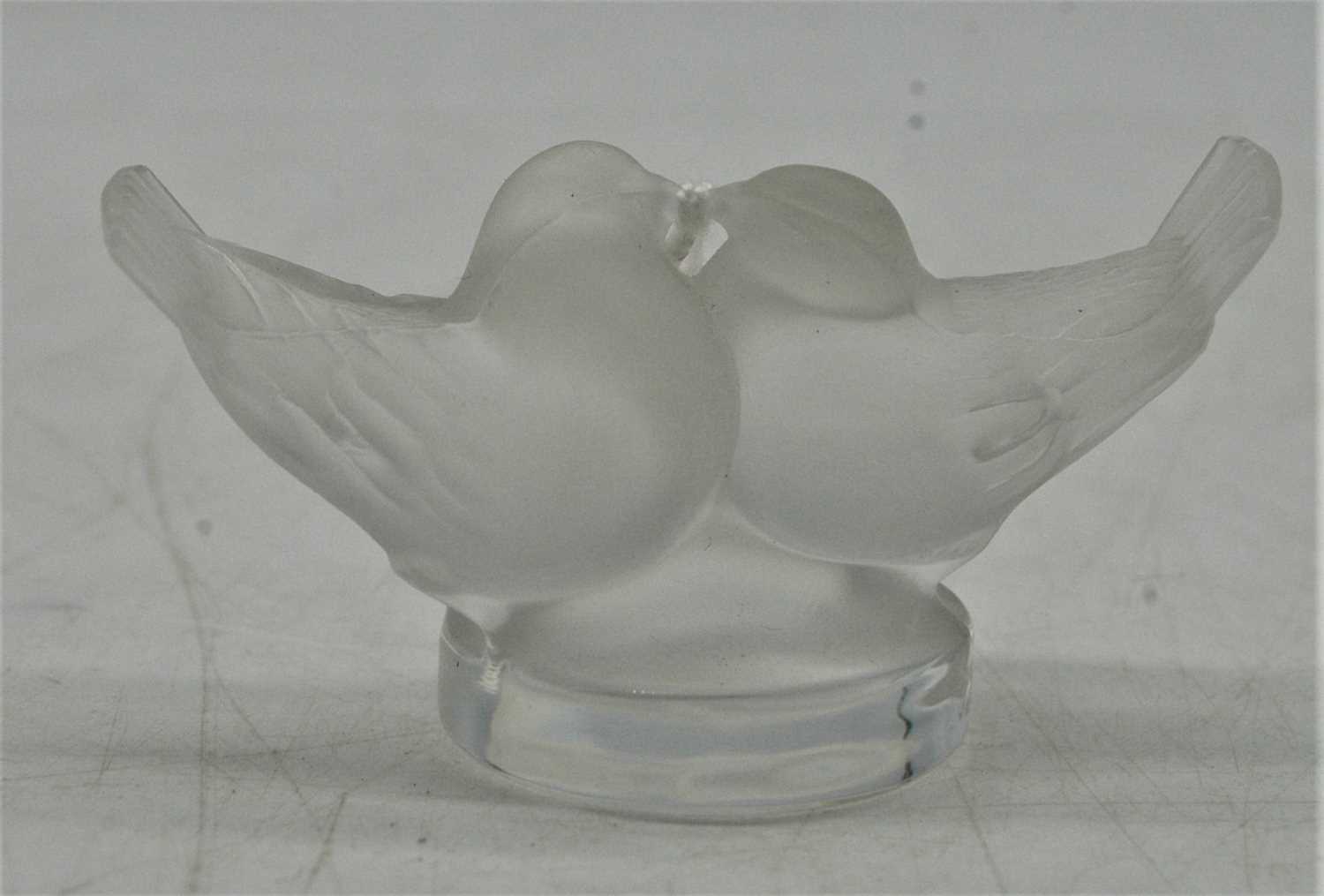 A small Lalique frosted glass table ornament, modelled as two lovebirds on a circular base, with