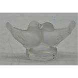 A small Lalique frosted glass table ornament, modelled as two lovebirds on a circular base, with